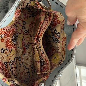 Brighton bag collection, light blue with multiple compartments inside.